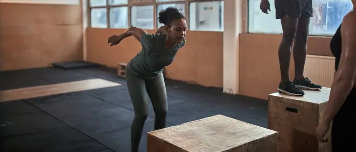 woman performing box jump for tennis strength training routine