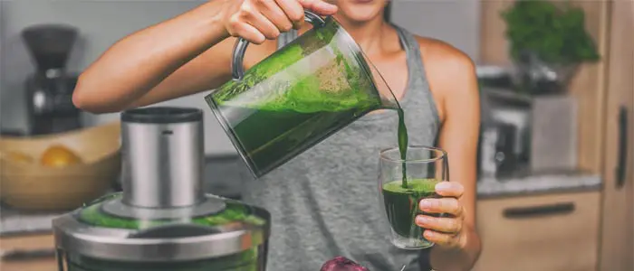 woman making a green detox smoothie
