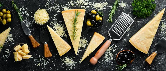 Cheese board displaying various hard cheeses and graters