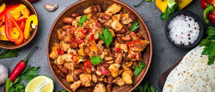 a Mexican dish surrounded by peppers and breads