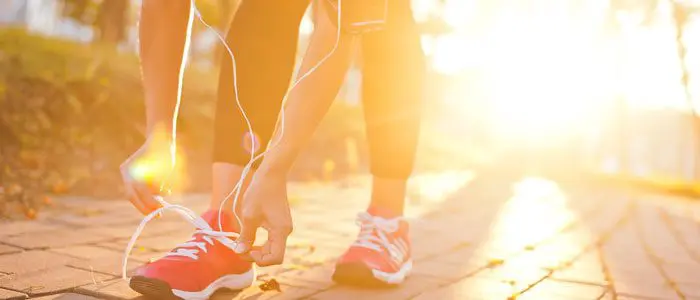 person outside tying laces before a run