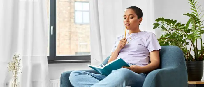 woman sat with a notebook planning her fitness goals - fitness questions