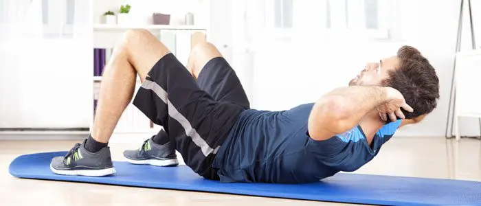 man doing push-ups on a mat in his home gym