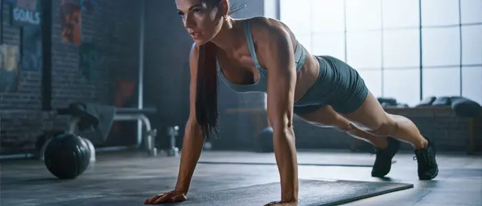 woman doing push-ups to strengthen arms and reduce bingo wings
