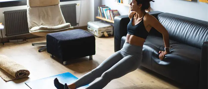 woman doing tricep dips on a sofa to reduce bingo wings