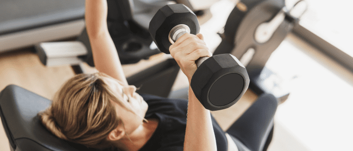 woman training with dumbbells on a weight bench - mirafit vs marcy