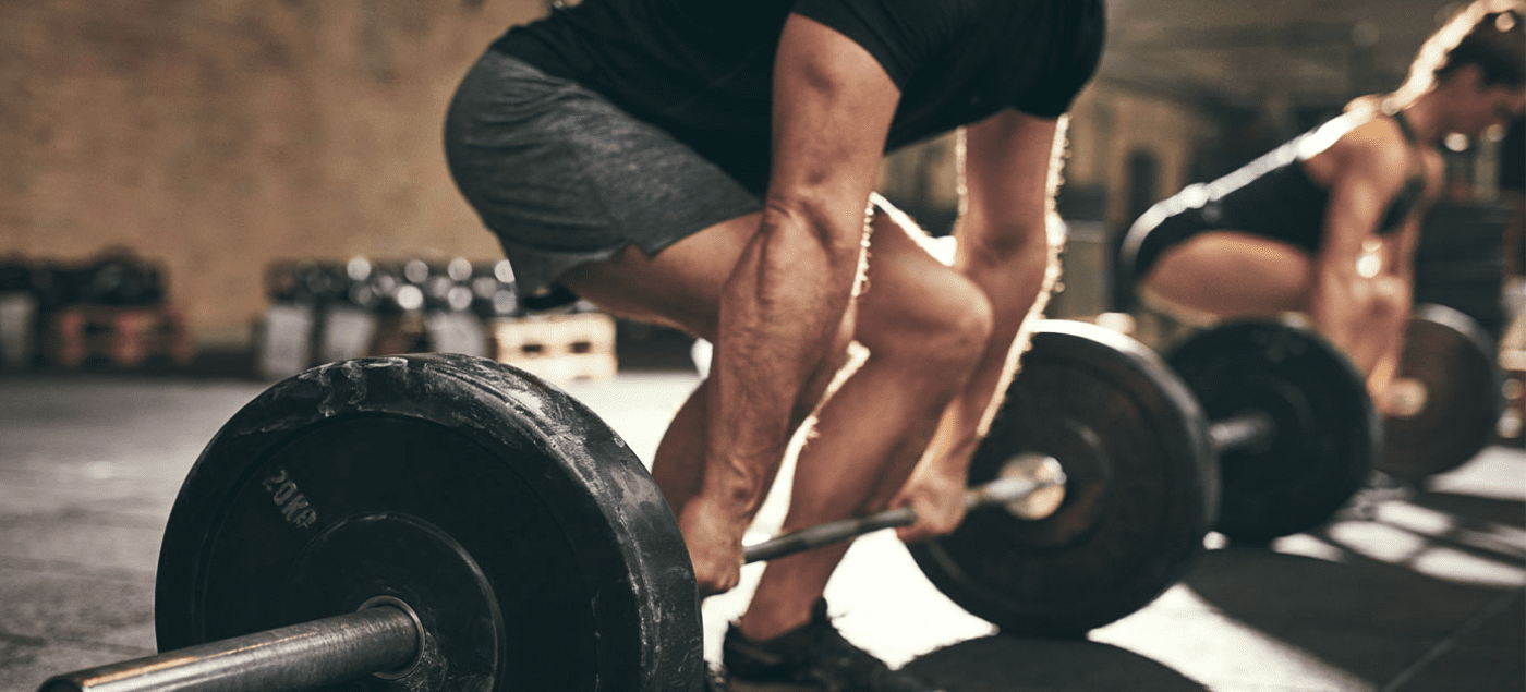 man doing deadlift with barbell and weight plates