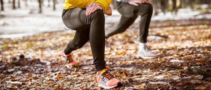 two people outdoors stretching before doing exercise in winter