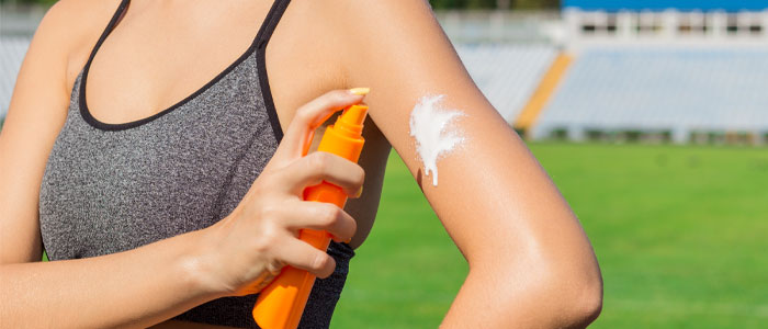 woman applying suncream before exercising in the heat
