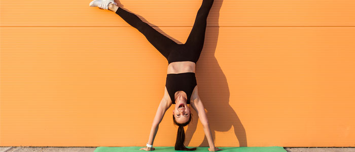 woman doing a handstand wall pilates